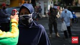 PENGAMBILAN BANSOS PKH Petugas kelurahan mengecek suhu warga sebelum mengambil paket bansos di Kelurahan Pondok Kelapa, Jakarta, Jumat, 12 Juni 2020. Bansos program keluarga harapan (PKH) sudah berlangsung sejak April untuk melindungi keluarga prasejahtera dari dampak Covid-19. Isi bansos yang diterima warga berupa beras, telur, jeruk dan ayam potong. CNNIndonesia/Safir Makki