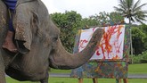 ALIH PROFESI GAJAH TUNGGANGAN DI BOROBUDUR Zella menggoreskan kuas di atas kertas di taman Lumbini, Borobudur.
