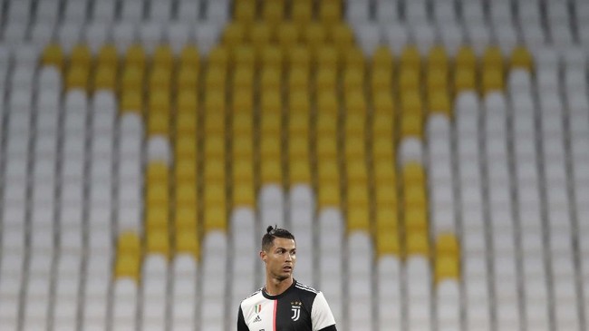 Juventus' Cristiano Ronaldo stands in front of the empty stands during an Italian Cup second leg soccer match between Juventus and AC Milan at the Allianz stadium, in Turin, Italy, Friday, June 12, 2020. The match was being played without spectators because of the coronavirus lockdown. (AP Photo/Luca Bruno)