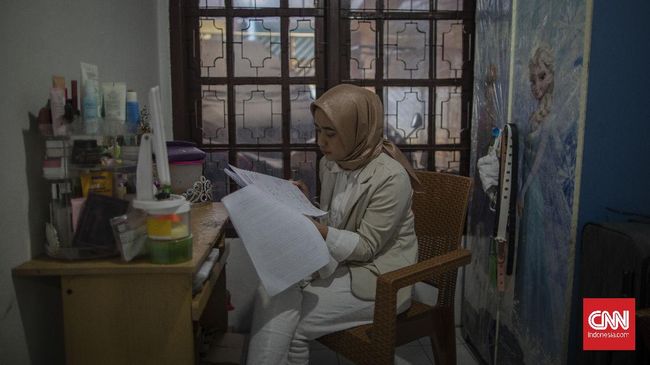 Pelita Mu'minatus Sholihah (21), mahasiswa Teknik Metalurgi dan Material Universitas Indonesia melaksanakan sidang skripsi secara online di kediamannya di kawasan Cimanggis, Depok, Jawa Barat. Sidang skripsi secara online ini menjadi siasat perguruan tinggi untuk mencegah penyebaran virus Covid-19. CNN Indonesia/Bisma Septalisma
