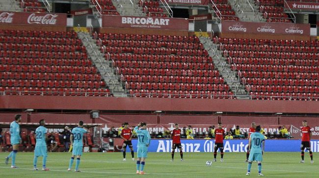 Mallorca and FC Barcelona players stand during a minute of silence before the start of their Spanish La Liga soccer match between Mallorca and FC Barcelona at Son Moix Stadium in Palma de Mallorca, Spain, Saturday, June 13, 2020. With virtual crowds, daily matches and lots of testing for the coronavirus, soccer is coming back to Spain. The Spanish league resumes this week more than three months after it was suspended because of the COVID-19 pandemic. (AP Photo/Francisco Ubilla)
