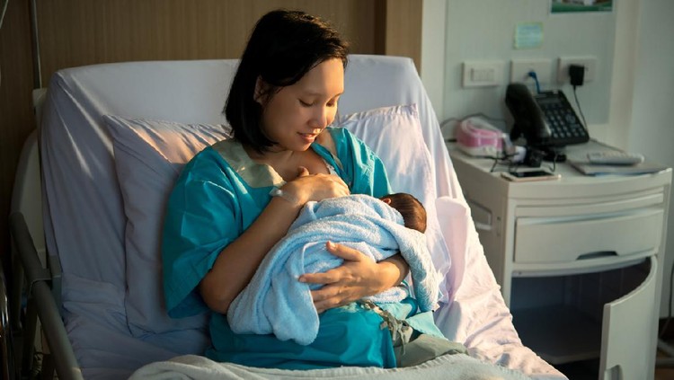 Ibu menyusui Mothers breastfeed while dating a beautiful golden sunset, golden light shines on the mother and child.
