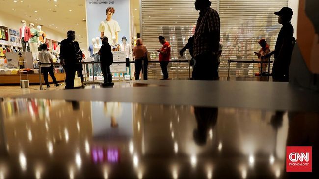 Menerapkan protokol kesehatan, tenant membatasi jumlah pengunjung, memeriksa suhu tubuh dan memberi jarak fisik saat antre masuk di Lotte Avenue Mall. (CNN Indonesia/ Safir Makki)
