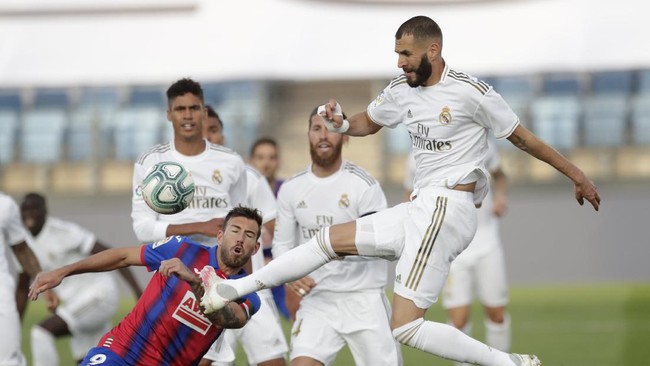Real Madrid's Karim Benzema, right, kicks the ball past Eibar's Sergi Enrich during the Spanish La Liga soccer match between Real Madrid and Eibar at Alfredo di Stefano stadium in Madrid, Spain, Sunday, June 14, 2020. (AP Photo/Bernat Armangue)