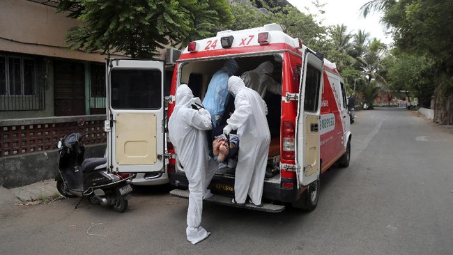 Izhaar Hussain Shaikh, left, an ambulance driver who works for HelpNow, an initiative to help the stretched services of first responders, picks up a COVID-19 patient from his home in Mumbai, India May 28, 2020. It’s an exhausting job and Shaikh's daily shifts are grueling, sometimes even stretching to 16 hours. For a city that has a history of shortage of ambulances and where coronavirus pandemic has claimed hundreds of lives, putting the health care system under immense strain, every help counts. (AP Photo/Rafiq Maqbool)