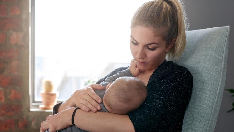 Young mother breastfeeding at home, bonding with baby child toddler