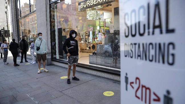 People wait in line for the opening of the Selfridges department store in London, Monday, June 15, 2020. After three months of being closed under coronavirus restrictions, shops selling fashion, toys and other non-essential goods are being allowed to reopen across England for the first time since the country went into lockdown in March.(AP Photo/Matt Dunham)