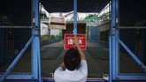 Taman Hiburan Tokyo Dibuka Kembali An employee posts a sign to suspend indoor facilities at the newly-opened Yomiuriland amusement park in Tokyo, Tuesday, June 16, 2020. The park has been closed since the end of March as a part of the precautions to help curb the spread of the coronavirus. (AP Photo/Eugene Hoshiko)