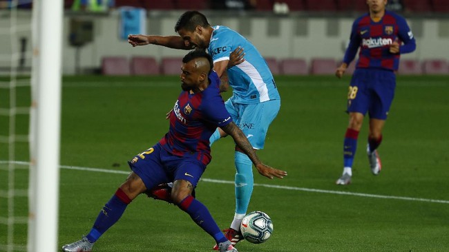 FC Barcelona's Arturo Vidal, left, in action during the Spanish La Liga soccer match between FC Barcelona and Leganes at the Camp Nou stadium in Barcelona, Spain, Tuesday, June 16, 2020. (AP Photo/Joan Montfort)
