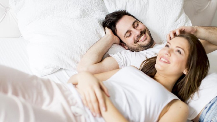 Young loving couple in bed. Happy couple relaxing in bed.