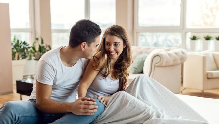 Young loving couple in bed. Happy couple relaxing in bed.