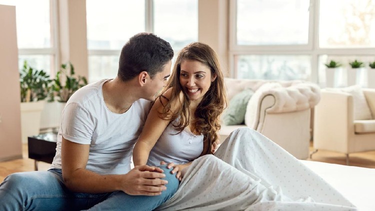 Young loving couple in bed. Happy couple relaxing in bed.