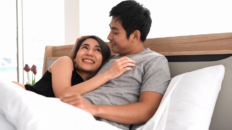 Young loving couple in bed. Happy couple relaxing in bed.