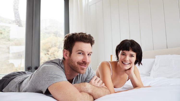 Young loving couple in bed. Happy couple relaxing in bed.