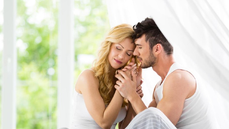 Young loving couple in bed. Happy couple relaxing in bed.