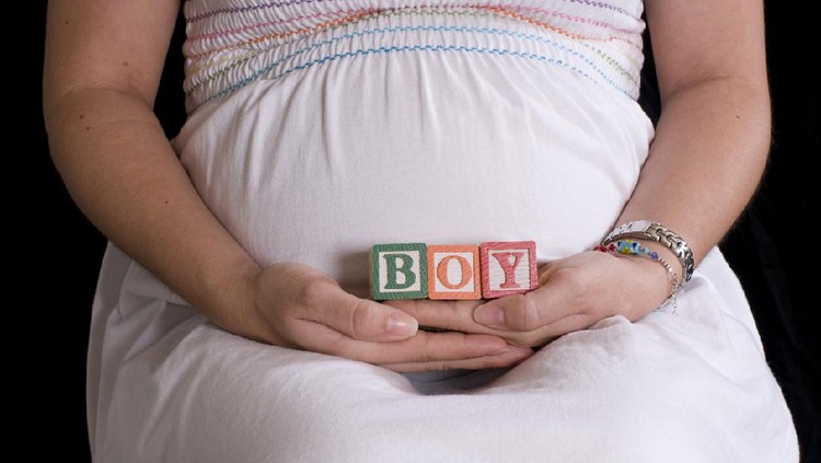 Pregnant woman with alphabet cubes spelling Boy
