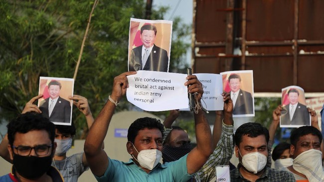 Indians holds photographs of Chinese president Xi Jinping during a protest against China in Ahmedabad, India, Tuesday, June 16, 2020. At least three Indian soldiers, including a senior army officer, were killed in a confrontation with Chinese troops along their disputed border high in the Himalayas where thousands of soldiers on both sides have been facing off for over a month, the Indian army said Tuesday. (AP Photo/Ajit Solanki)