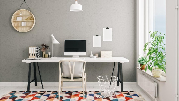Posters on grey wall above white cupboard in bright living room interior with sofa and carpet. Real photo