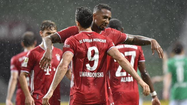 Bayern's Robert Lewandowski, foreground, celebrates with his teammate Bayern's Jerome Boateng after scoring his side's opening goal during the German Bundesliga soccer match between Werder Bremen and Bayern Munich in Bremen, Germany, Tuesday, June 16, 2020. Because of the coronavirus outbreak all soccer matches of the German Bundesliga take place without spectators. (AP Photo/Martin Meissner, Pool)