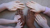 Albino di Zimbabwe Joyce Muchenje, centre, places her hands on a wall and that of her three children, who all have albinism, outside their family home in Chitungwiza on the outskirts of Harare, in this Tuesday, June, 9, 2020 photo. Muchenje used to provide for them by washing laundry and household cleaning for cross border traders at a busy border town before the lockdown, but now the border trade has stopped and Mutenje has run out of money to get the skin cream for her children. (AP Photo/Tsvangirayi Mukwazhi)