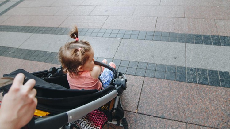 Mother pushing a stroller outdoors,rear view,high angle view