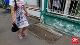 KUBURAN DI TENGAH JALAN PISANGAN Warga melintasi kuburan yang ada di pinggir gang pemukiman di Pisangan, Jakarta Timur, Jumat, 19 Juni 2020. Meski keberadaannya berada di jalanan gang rumah warga. Selain karena tidak terganggu, warga sekitar tetap mempertahankan kuburan tersebut karena karena masih ada keluarga yang berziarah dan mengunjunginnya. Kuburan tersebut berasal dari daerah Pisangan yang dulunya menjadi tempat pemakaman warga sekitar. CNN Indonesia/Safir Makki