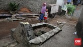 KUBURAN DI TENGAH JALAN PISANGAN Warga melintasi kuburan yang ada di antara pemukiman warga di Pisangan, Jakarta Timur, Jumat, 19 Juni 2020. Selain karena tidak terganggu, warga sekitar tetap mempertahankan kuburan tersebut karena karena masih ada keluarga yang berziarah dan mengunjunginnya. Kuburan tersebut berasal dari daerah Pisangan yang dulunya menjadi tempat pemakaman warga sekitar. CNN Indonesia/Safir Makki