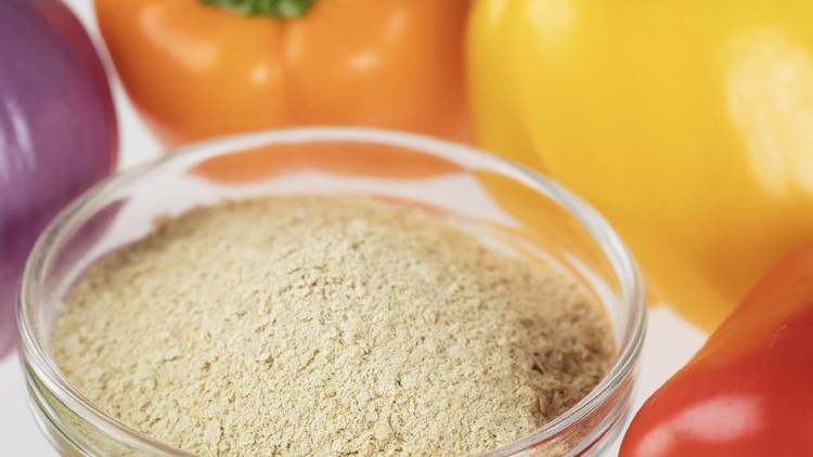 Nutritional yeast on green wooden background