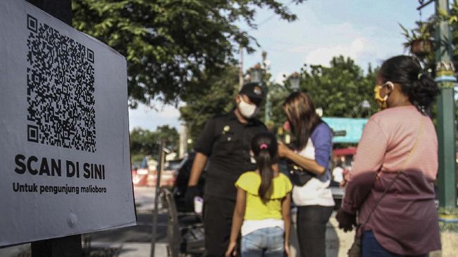 Rencana Penerapan Normal Baru di Wisata Yogyakarta Petugas Jogoboro membantu pengunjung mengisi data diri di pintu masuk kawasan Malioboro, DI Yogyakarta, Rabu (17/6/2020). Pemerintah Kota Yogyakarta mewajibkan setiap pengunjung memindai kode untuk mengisi data diri guna memudahkan proses monitor pengunjung pada masa transisi normal baru di Yogyakarta selama pandemi COVID-19. ANTARA FOTO/Hendra Nurdiyansyah/foc.