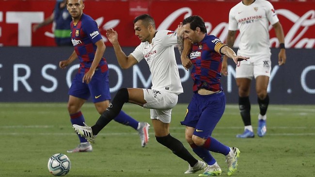 FC Barcelona's Lionel Messi, right, vies for the ball with Sevilla's Joris Gnagnon during the Spanish La Liga soccer match between Sevilla and FC Barcelona at the Ramon Sanchez-Pizjuan stadium in Seville, Spain, Friday, June 19, 2020. (AP Photo/Angel Fernandez)
