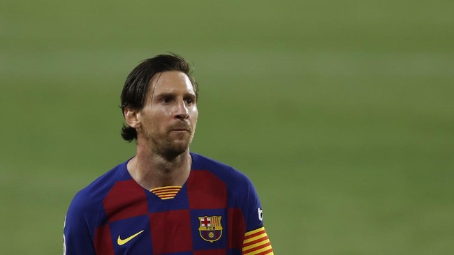 Barcelona's Lionel Messi, left, falls next to Sevilla's Diego Carlos during the Spanish La Liga soccer match between Sevilla and FC Barcelona at the Ramon Sanchez-Pizjuan stadium in Seville, Spain, Friday, June 19, 2020. (AP Photo/Angel Fernandez)