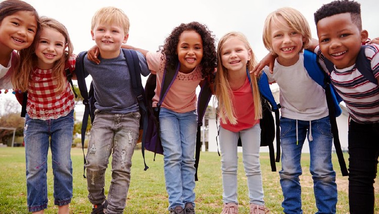 Portrait Of Excited Elementary School Pupils On Playing Field At Break Time