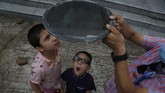 Antusiasme amati gerhana matahari 2020 Nepalese children watch solar eclipse through a dark glass in Kathmandu, Nepal, Sunday, June 21, 2020. (AP Photo/Niranjan Shrestha)