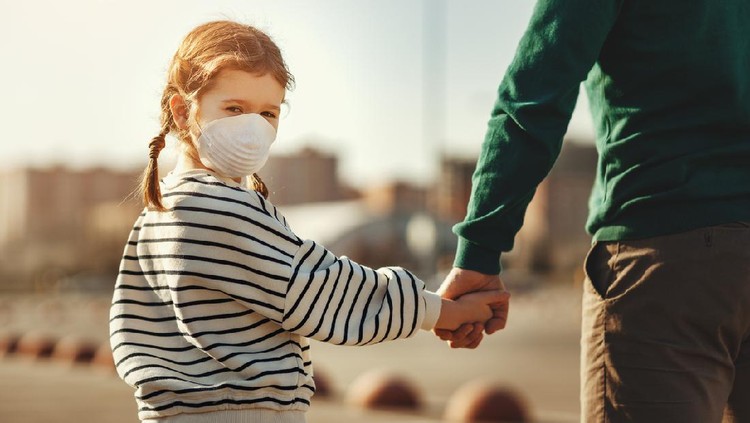 Little boy in medical mask hugging crop mother and looking at camera during coronavirus outbreak against gray background