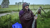 Perayaan Titik Balik Matahari A man stands beside a barbed wire fence next to the closed Stonehenge as people gather to celebrate the dawn of the longest day, the Summer Solstice, near Salisbury, England, Sunday June 21, 2020. (Ben Birchall/PA via AP)