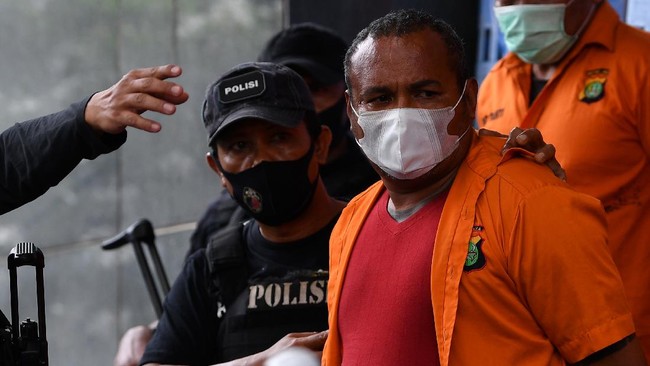 Polisi membawa salah satu tersangka kejahatan John Kei saat rilis di Polda Metro Jaya, Jakarta, Senin (22/6/2020). Tim gabungan Polda Metro Jaya berhasil menangkap 30 orang yakni John Kei beserta anggota kelompoknya dalam kasus pengeroyokan, pembunuhan dan kekerasan di kawasan Duri Kosambi, Jakarta Barat dan Perumahan Green Lake City, Kota Tangerang, Banten pada Minggu 21 Juni 2020. ANTARA FOTO/Sigid Kurniawan/wsj.
