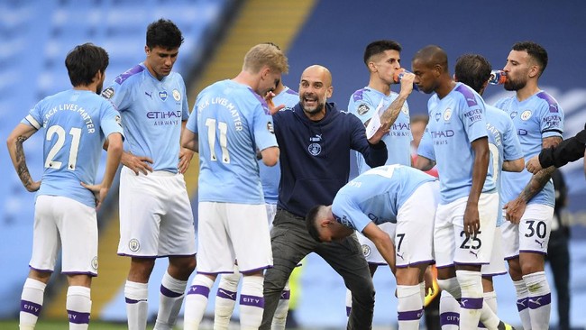 Manchester City's head coach Pep Guardiola gestures as he talks with his players during a drinks break in the English Premier League soccer match between Manchester City and Burnley at Etihad Stadium, in Manchester, England, Monday, June 22, 2020. (AP Photo/Michael Regan,Pool)