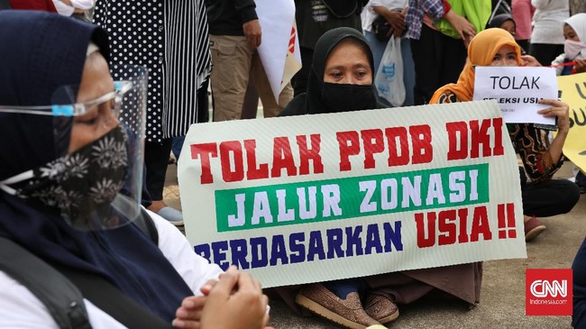 Gerombolan orang tua yang tergabung dalam Gerakan Emak dan Bapak Peduli Pendidikan dan Keadilan (GEPRAK) menyemut di depan Balai Kota Jakarta menyuarakan kritik soal Penerimaan Peserta Didik Baru (PPDB) 2020, Selasa, 23 Juni 2020. Mereka meminta Gubernur DKI Jakarta Anies Baswedan menghapus aturan usia pada PPDB DKI Jakarta, karena banyak yang anaknya tak lolos ke SMP dan SMA yang dituju. CNN Indonesia/Safir Makki
