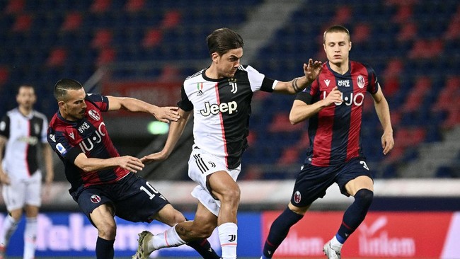 Juventus' Paulo Dybala, center, in action with Bologna's Nicola Sansone, left, during the Serie A soccer match between Bologna FC and Juventus FC at Stadio Renato Dall'Ara stadium in Bologna, Monday June 22, 2020. (Massimo Paolone/LaPresse via AP)