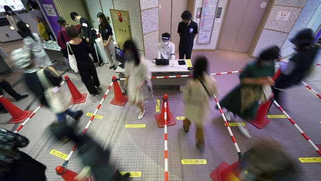Shoppers maintain social distancing as they walk in line to enter reopened Shibuya 109, a landmark and fashion building in Shibuya shopping district June 1, 2020, in Tokyo. As Japanese return to schools, shops and offices reconfigured to help prevent new coronavirus infections with ample use of plastic screens, masks and reminders to keep their distance, access to faster testing is crucial, officials say.(AP Photo/Eugene Hoshiko)