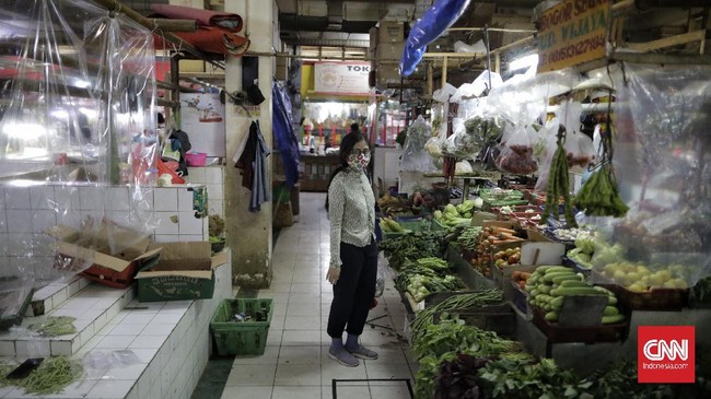 Plastik pembatas antara pedagang dan pembeli dipasang pedagang di kios mereka di Pasar Santa, Jakarta, Selasa, 23 Juni 2020. Pemasangan plastik ini merupakan sebagian dari protokol kesehatan pencegahan Covid-19 yang diterapkan di pasar ini. CNN Indonesia/Adhi Wicaksono
