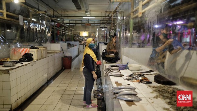 Plastik pembatas antara pedagang dan pembeli dipasang pedagang di kios mereka di Pasar Santa, Jakarta, Selasa, 23 Juni 2020. Pemasangan plastik ini merupakan sebagian dari protokol kesehatan pencegahan Covid-19 yang diterapkan di pasar ini. CNN Indonesia/Adhi Wicaksono
