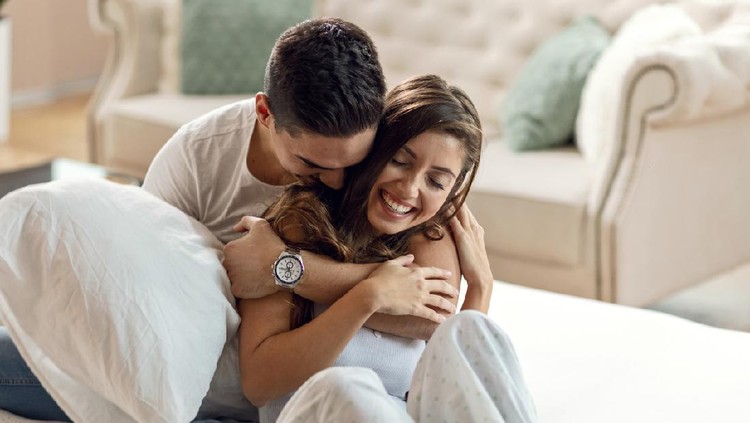 1132153686 Happy affectionate couple enjoying in their love while embracing in bedroom in the morning.