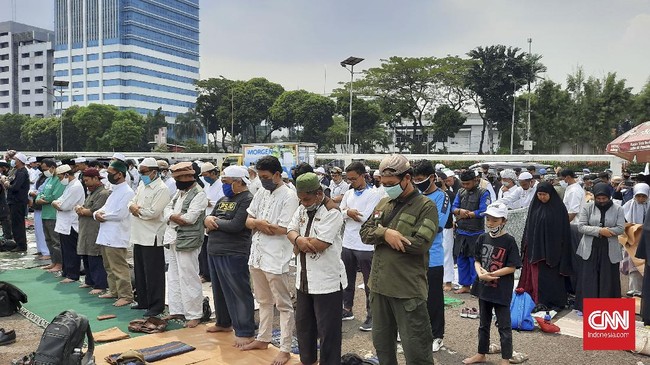 Massa pengunjuk rasa tolak Rancangan Undang-Undang Haluan Ideologi Pancasila (RUU HIP) menggelar salat Zuhur di depan gerbang area kompleks MPR/DPR, Rabu (24/6).