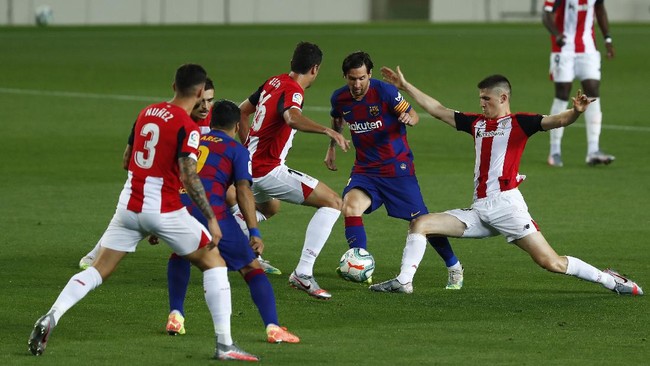 Barcelona's Lionel Messi, center, vies for the ball with Athletic Bilbao's Unai Nunez, center left, during the Spanish La Liga soccer match between FC Barcelona and Athletic Bilbao at the Camp Nou stadium in Barcelona, Spain, Tuesday, June 23, 2020. (AP Photo/Joan Monfort)