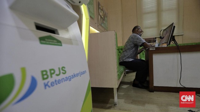 Peserta BP Jamsostek berkomunikasi dengan petugas pelayanan  secara daring saat mengurus klaim di Kantor Cabang BP Jamsostek Salemba, Jakarta. Untuk memutus penyebaran virus korona baru, BP Jamsostek menerapkan protokol pelayanan secara daring. (CNN Indonesia/ Adhi Wicaksono)