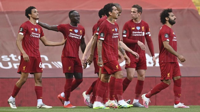 Liverpool's Trent Alexander-Arnold, left, celebrates after scoring the opening goal during the English Premier League soccer match between Liverpool and Crystal Palace at Anfield Stadium in Liverpool, England, Wednesday, June 24, 2020. (Paul Ellis/Pool via AP)