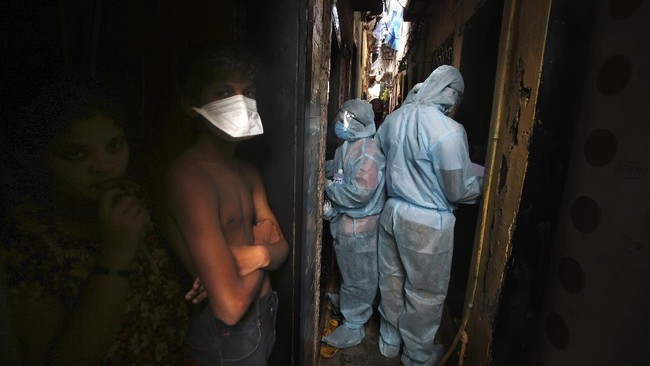 Indian health workers wearing personal protective equipment perform door to door check up during a check up camp at a slum in Mumbai, India, Wednesday, June 17, 2020. India is the fourth hardest-hit country by the COVID-19 pandemic in the world after the U.S., Russia and Brazil. (AP Photo/Rafiq Maqbool)