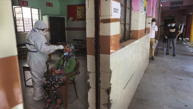 A health worker takes a swab sample of a woman for the COVID-19 rapid antigen test as other waits , in New Delhi, India, Wednesday, June 24, 2020. India records the highest spike of more than 15,000 new coronavirus cases in the last 24 hours, with Mumbai and New Delhi as the worst-hit cities in the country. India is the fourth hardest-hit country by the pandemic in the world after the U.S., Russia and Brazil. (AP Photo/Manish Swarup)
