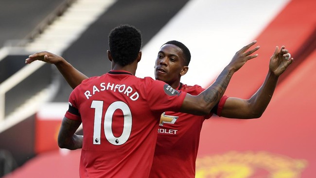 Manchester United's Anthony Martial, right, celebrates after scoring the opening goal of his team during the English Premier League soccer match between Manchester United and Sheffield United at Old Trafford in Manchester, England, Wednesday, June 24, 2020. (Michael Regan/Pool via AP)